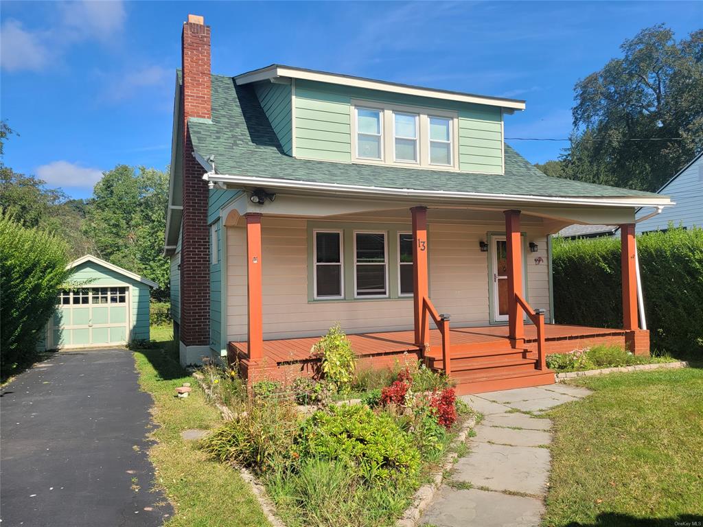 Bungalow featuring an outdoor structure, a porch, and a garage