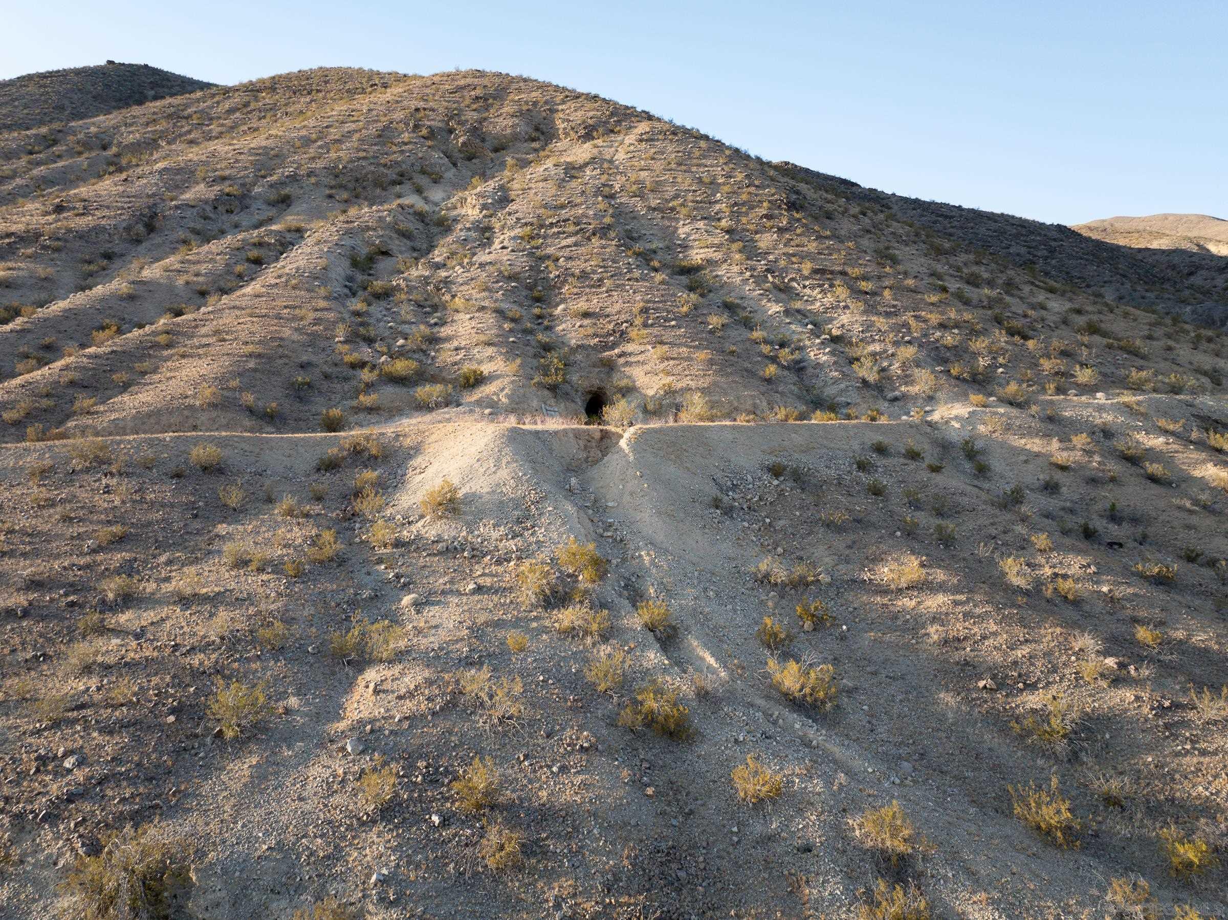 a view of a dry yard with mountains in the background