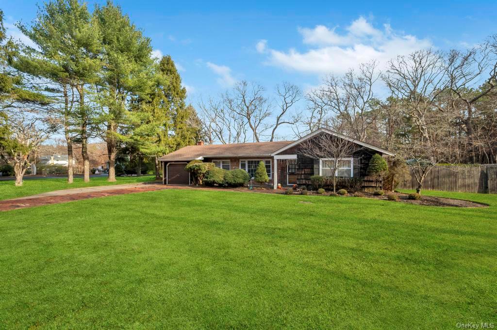 Single story home with a garage and a front lawn