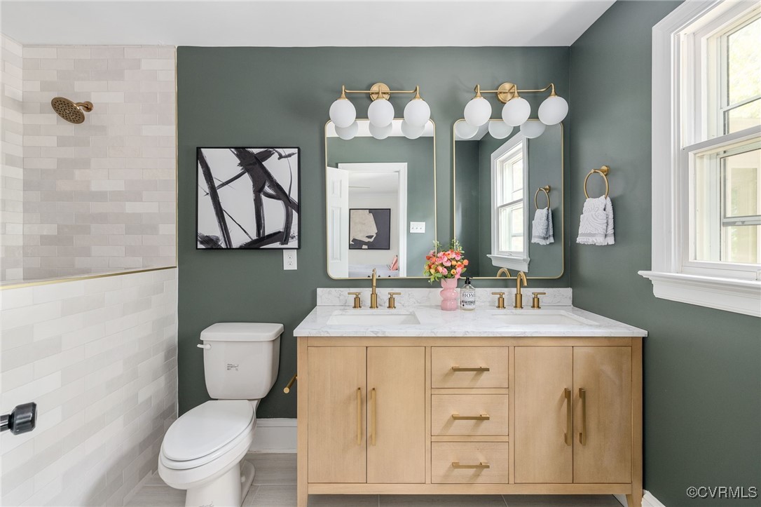 a bathroom with a sink vanity mirror and toilet