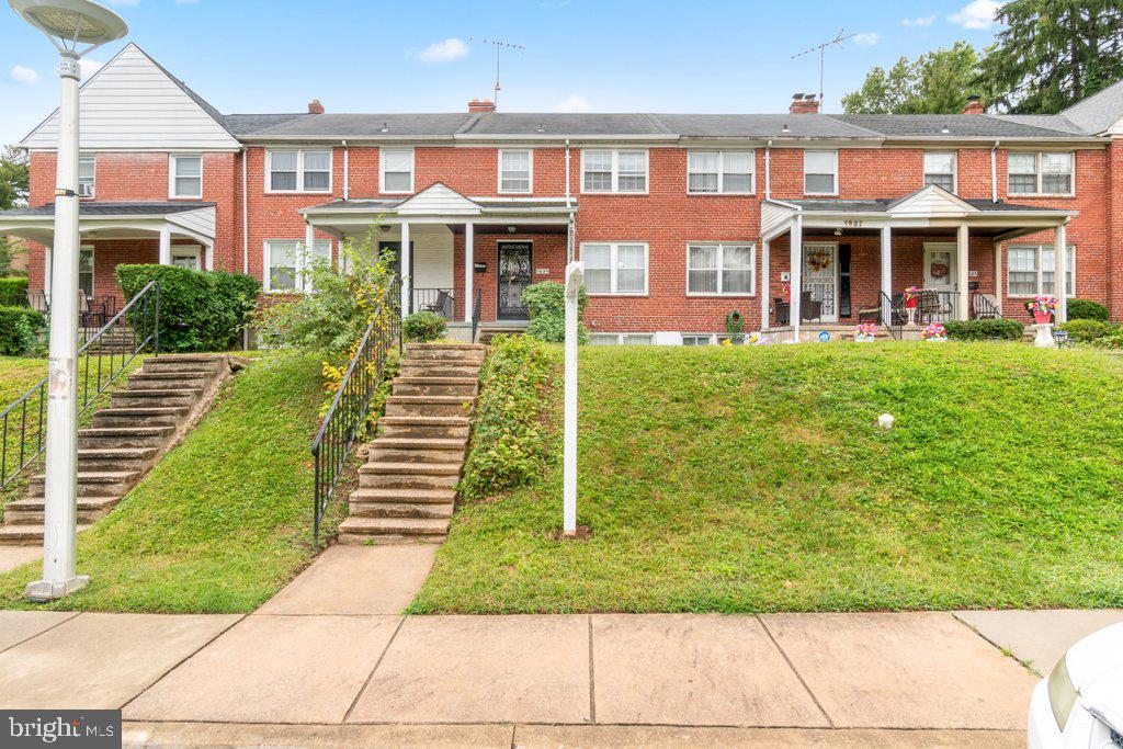 a front view of a residential apartment building with a yard