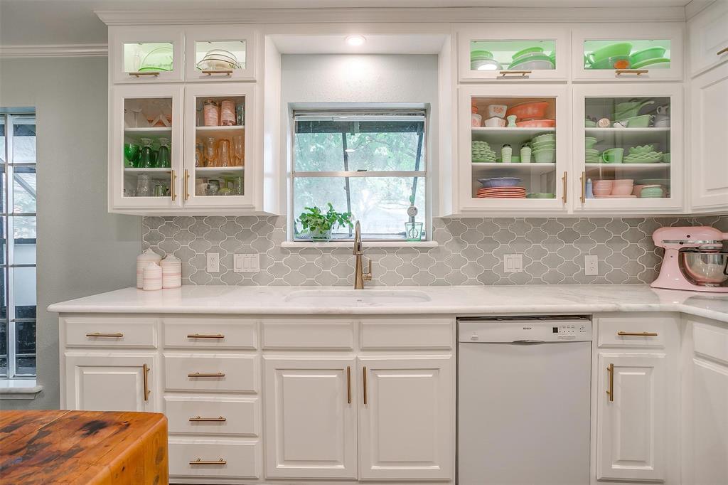 a kitchen with granite countertop a window sink and cabinets