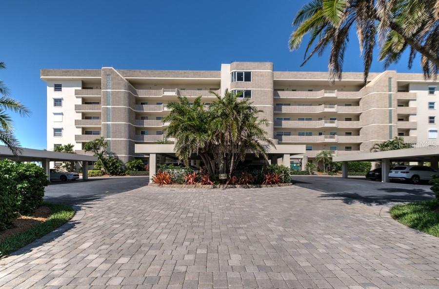 a front view of a building with palm trees