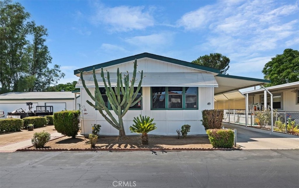 a front view of a house with a garden and mountain view