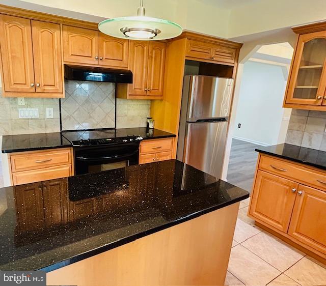 a kitchen with granite countertop a refrigerator a stove and a sink