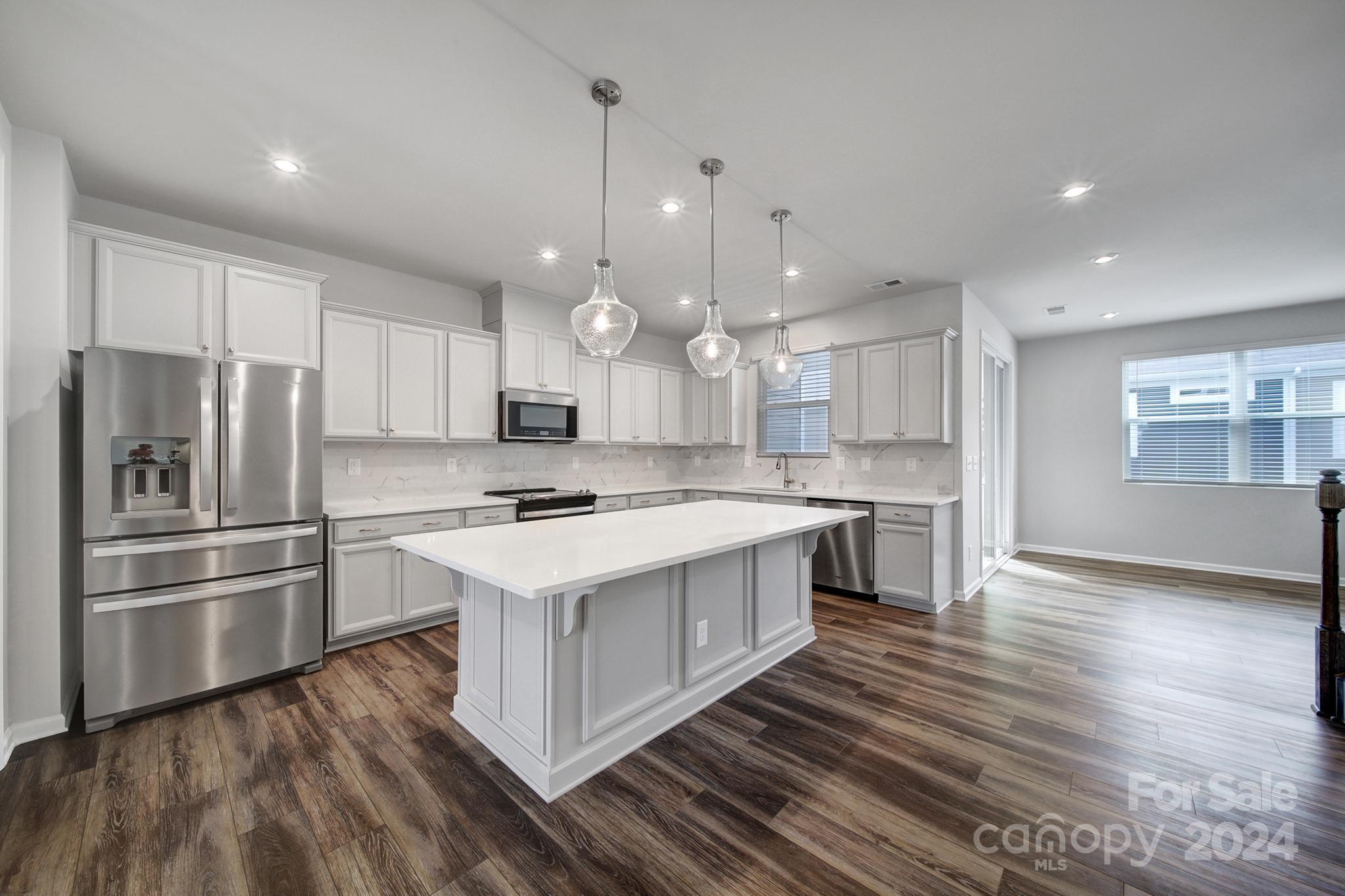 a kitchen with kitchen island a sink stainless steel appliances and cabinets