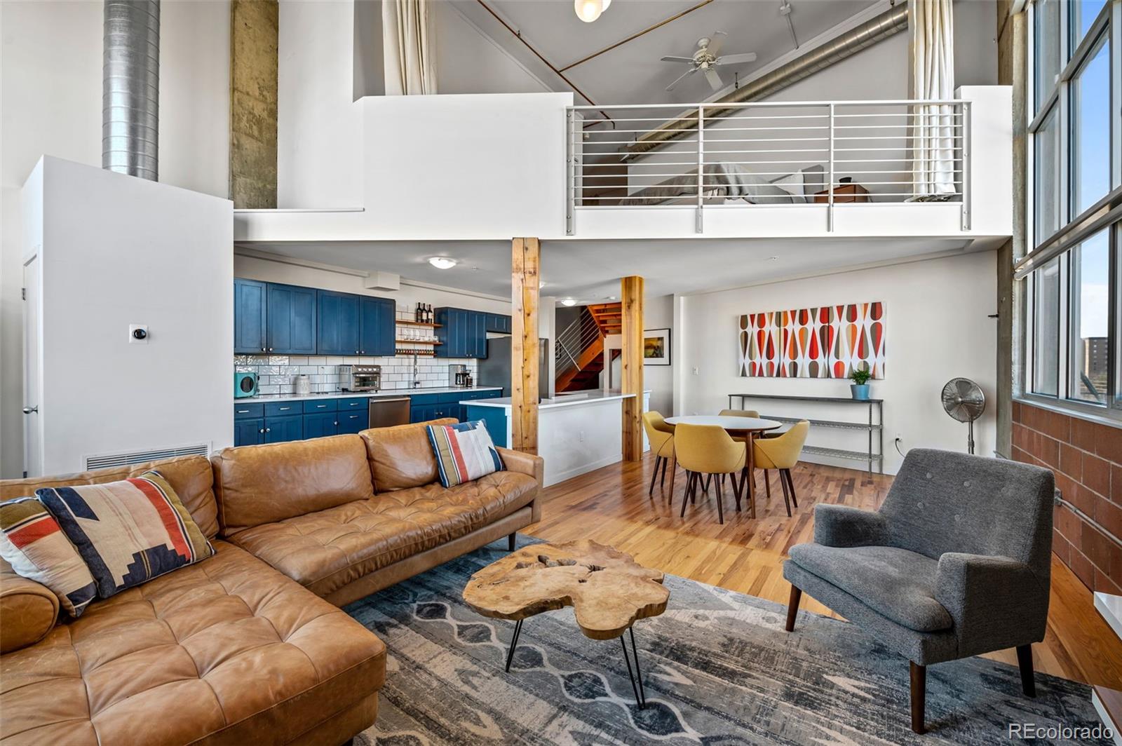 a living room with furniture a rug and kitchen view