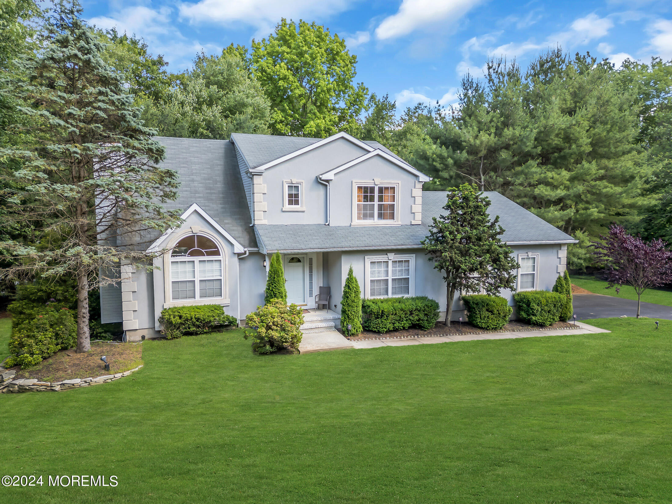 a front view of a house with a yard and trees