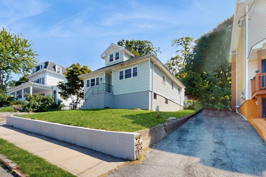 a front view of a house with a yard and potted plants