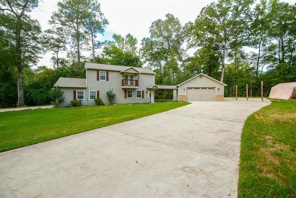 a view of a house with a yard and large tree