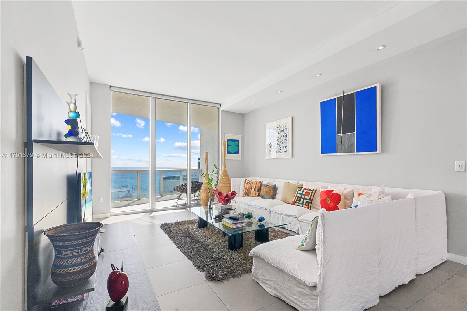 a living room with furniture and a floor to ceiling window