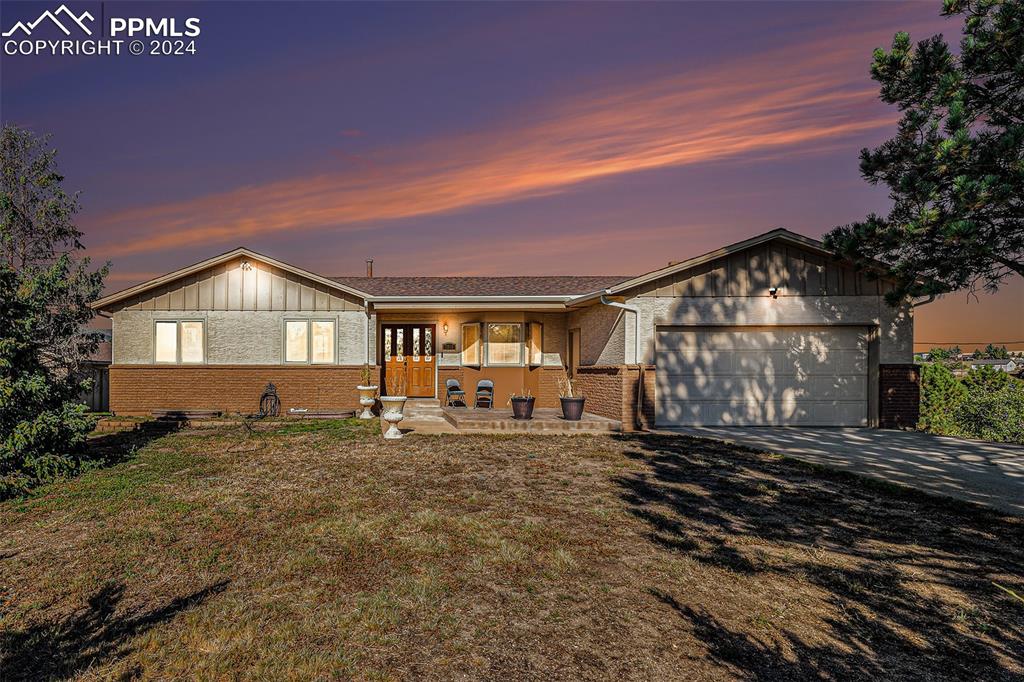 Single story home featuring a yard and a garage