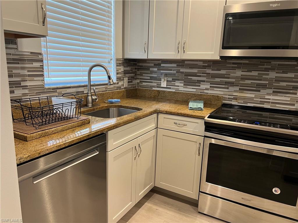 a kitchen with appliances a sink and cabinets