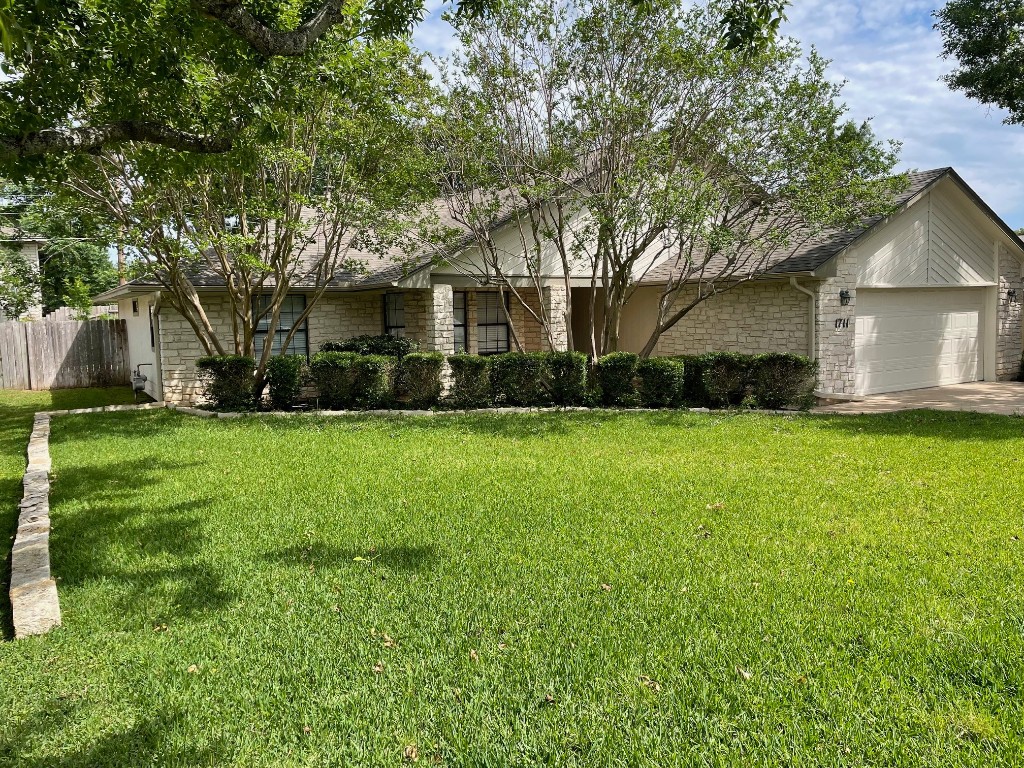 a front view of house with yard and green space