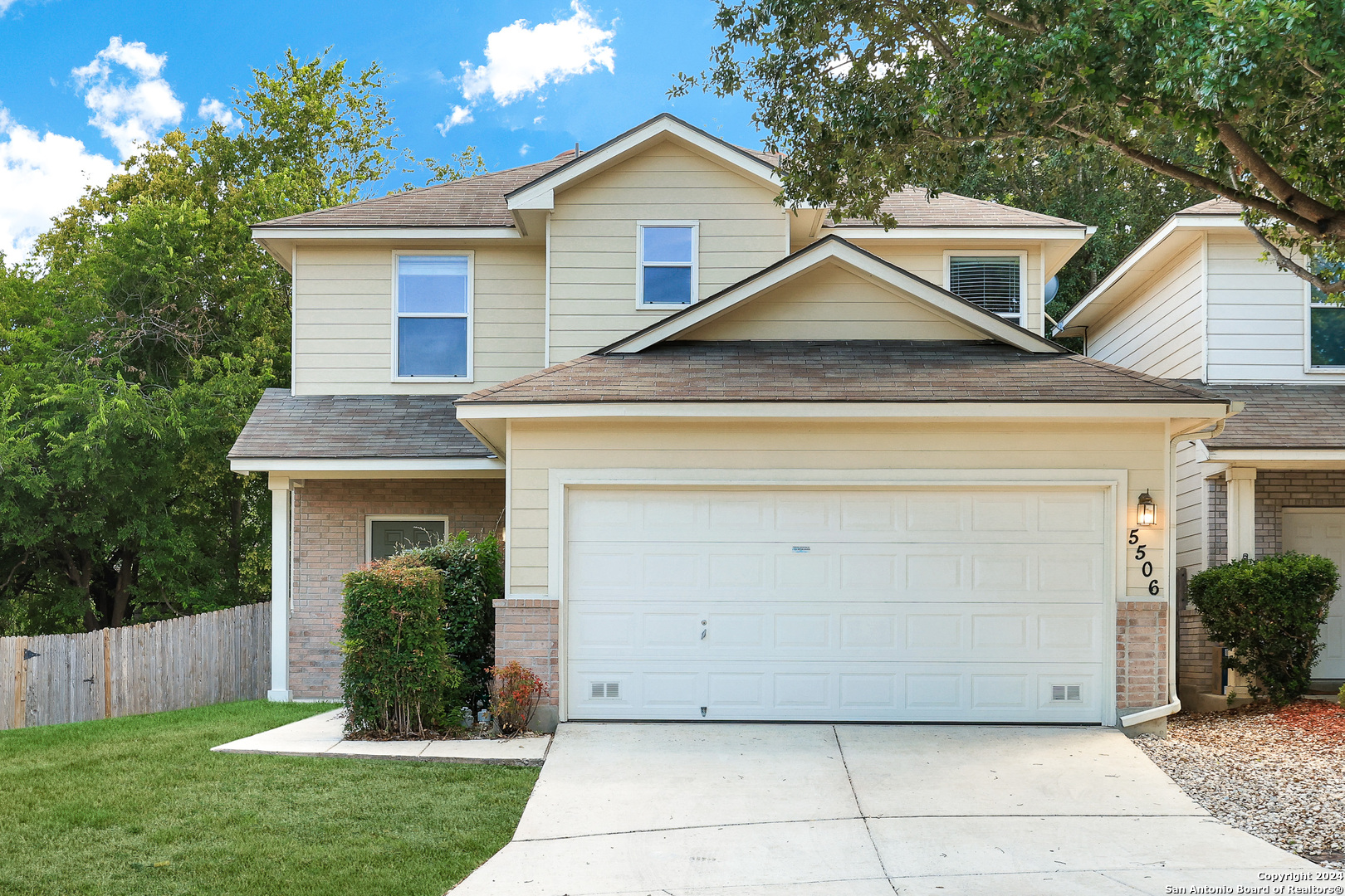 a view of a house with a yard and a garage