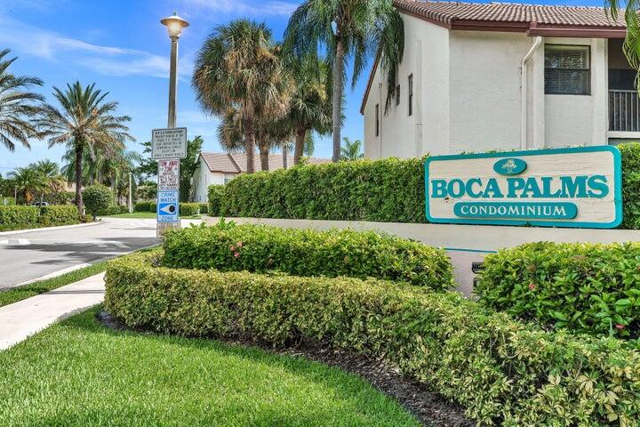 a view of sign board with a yard and potted plants