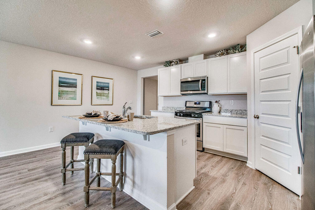 a kitchen with a sink cabinets and wooden floor