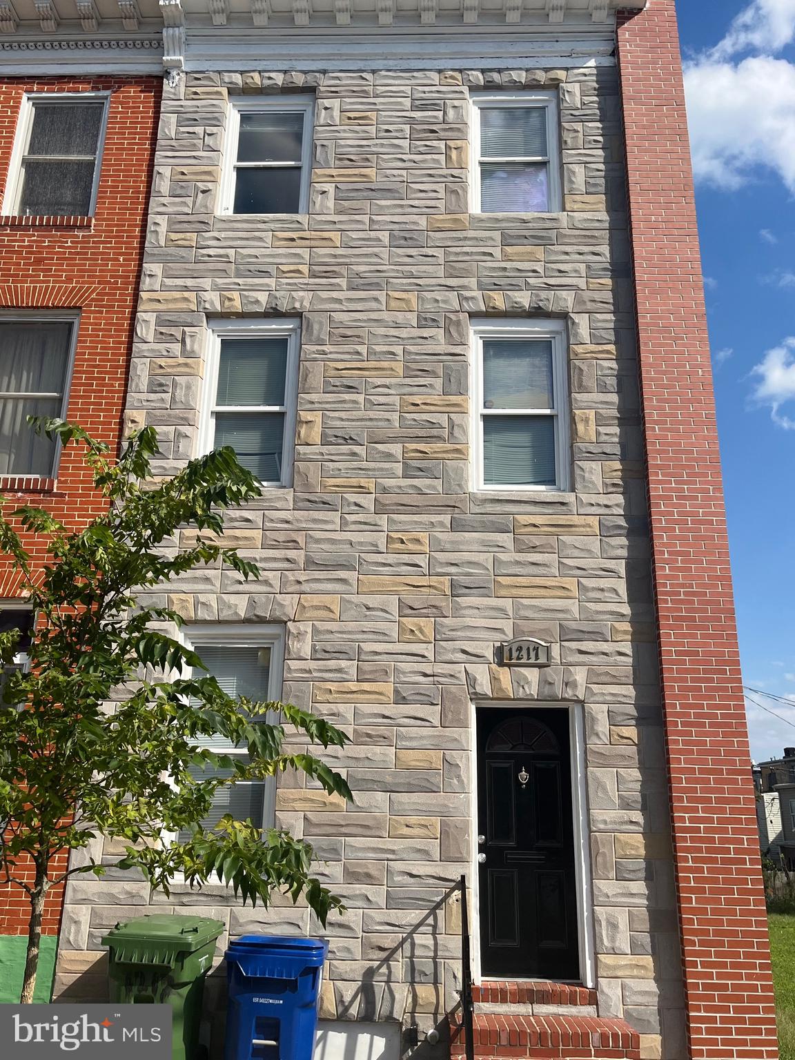 a brick building with a door and a yard