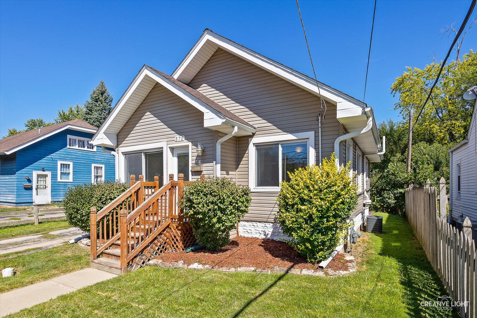 a view of a house with a yard and potted plants