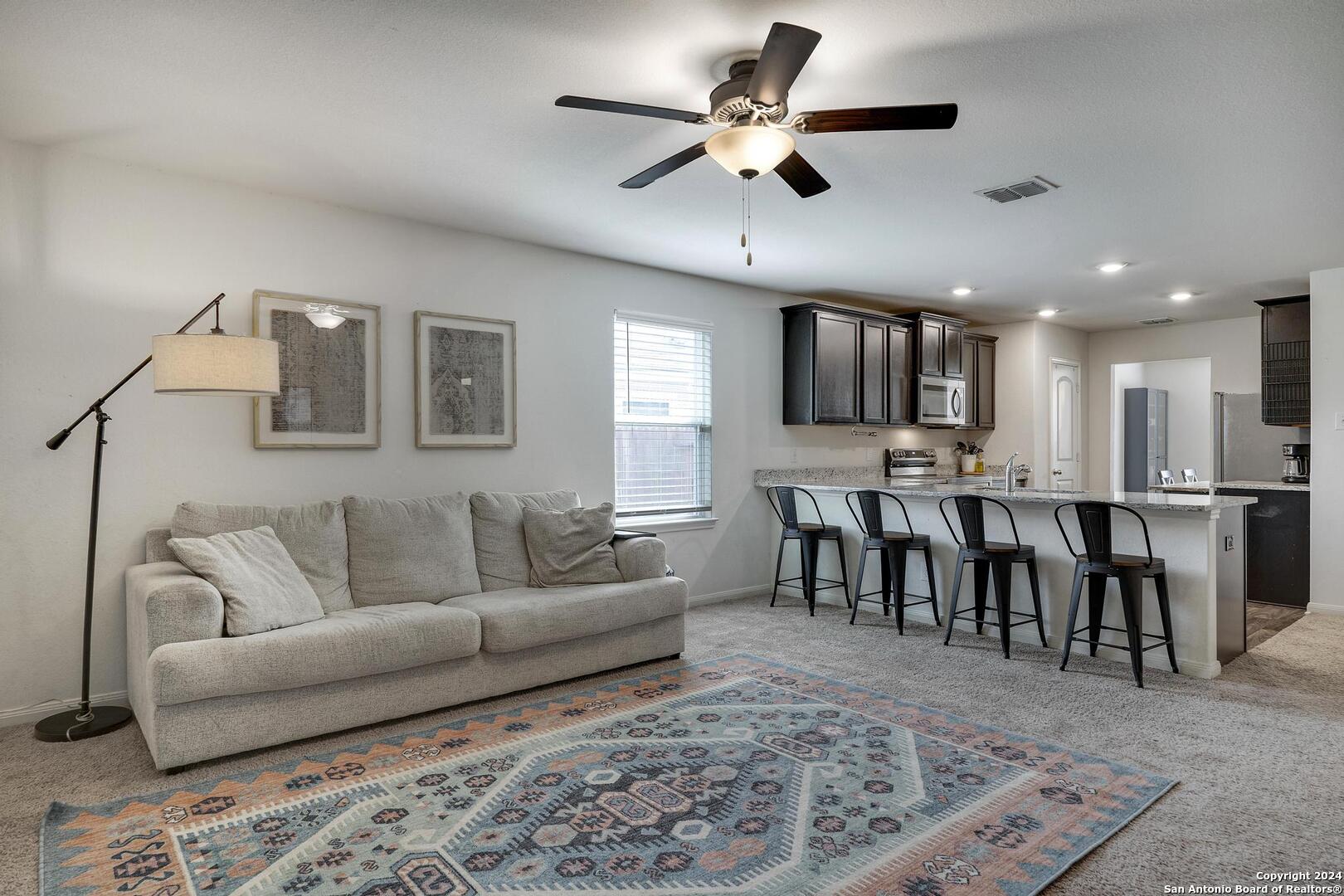 a living room with furniture kitchen view and a dining table