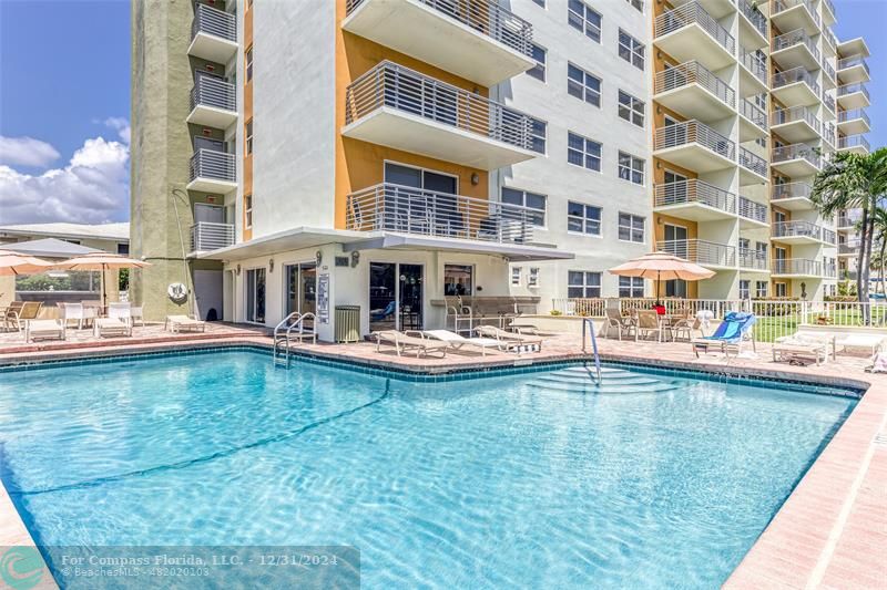 a swimming pool view with a outdoor seating