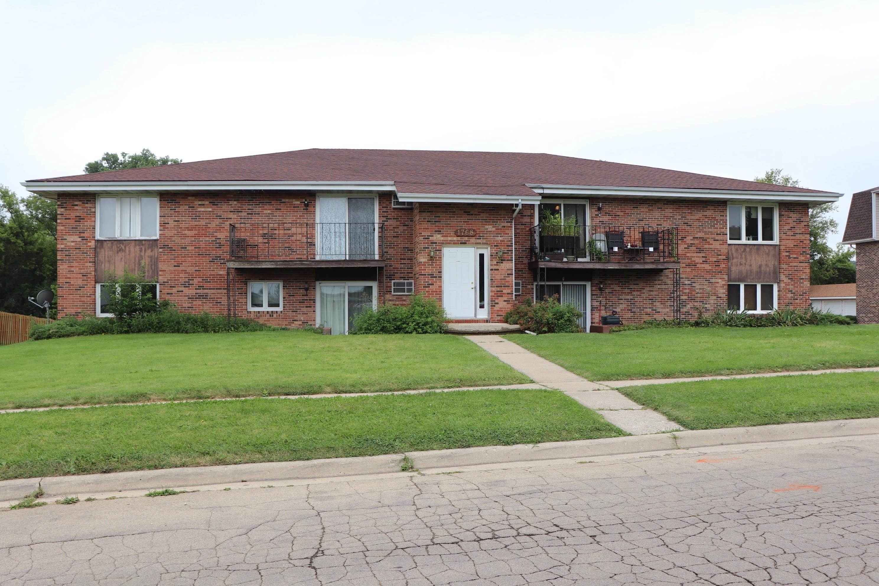 a front view of a house with a yard and trees