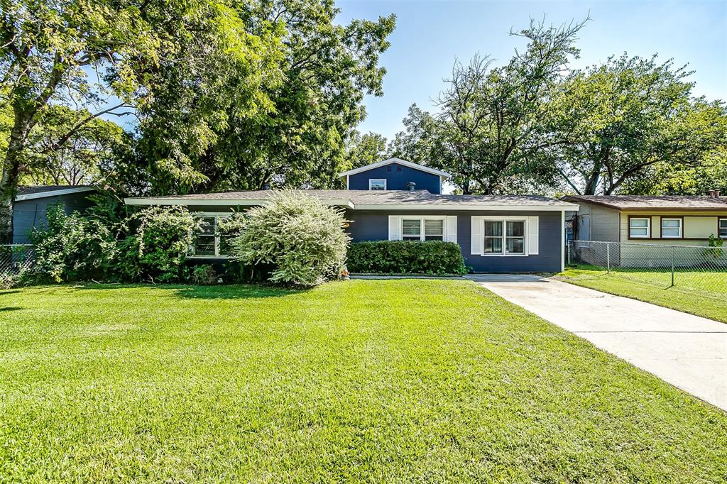 a front view of a house with a yard and trees