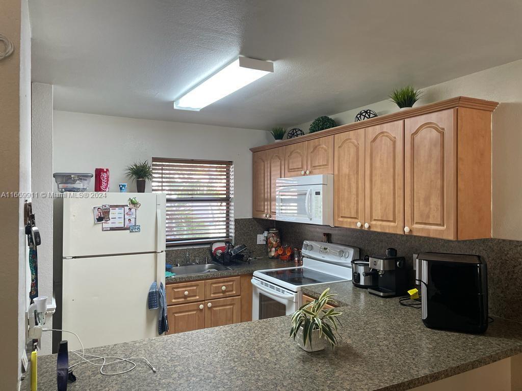 a kitchen with a refrigerator and a stove top oven