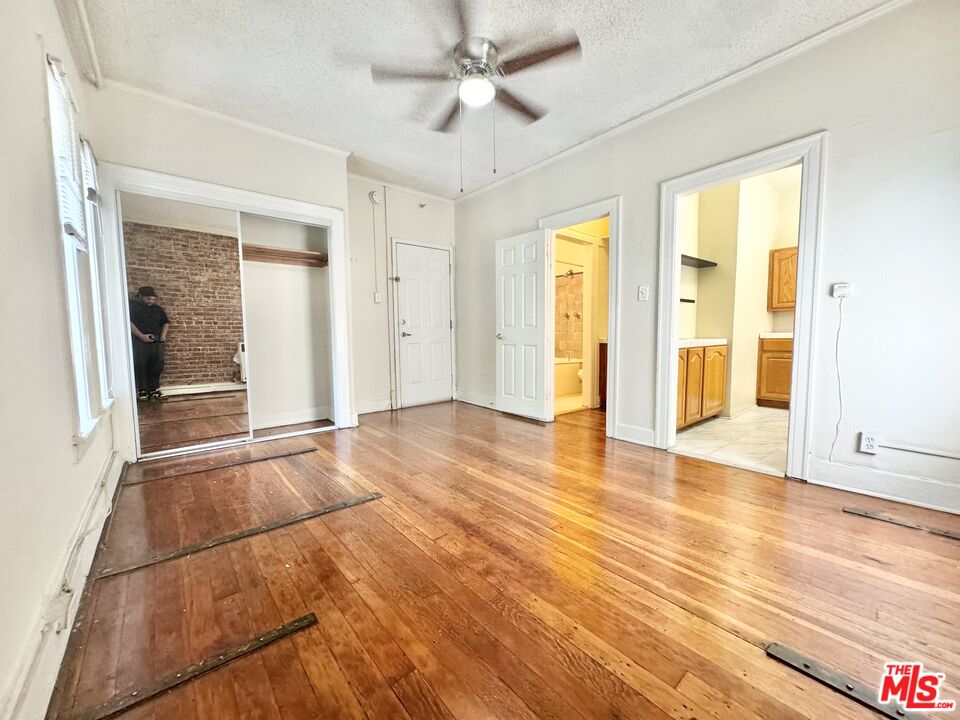 a view of an empty room with window and wooden floor