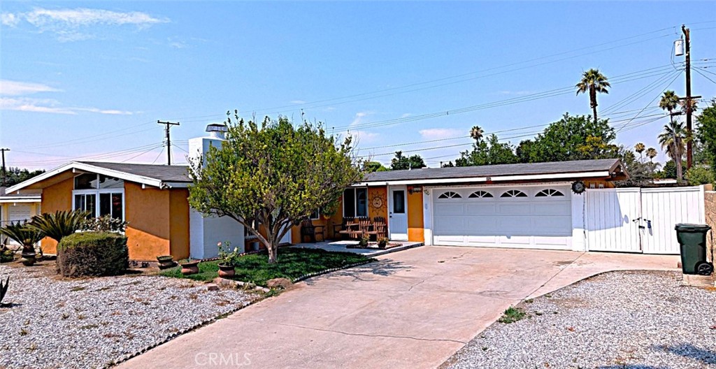 a view of a house with a yard and potted plants