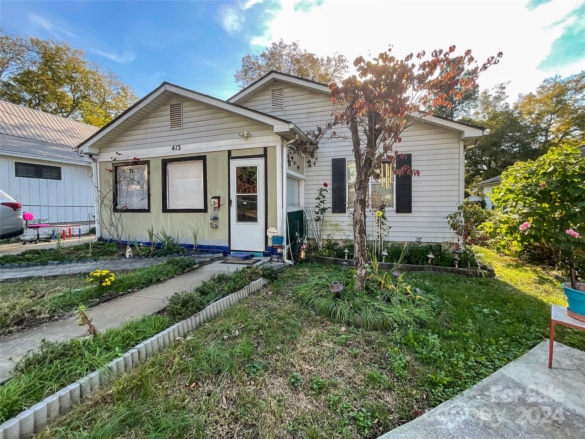 a front view of a house with a garden and plants