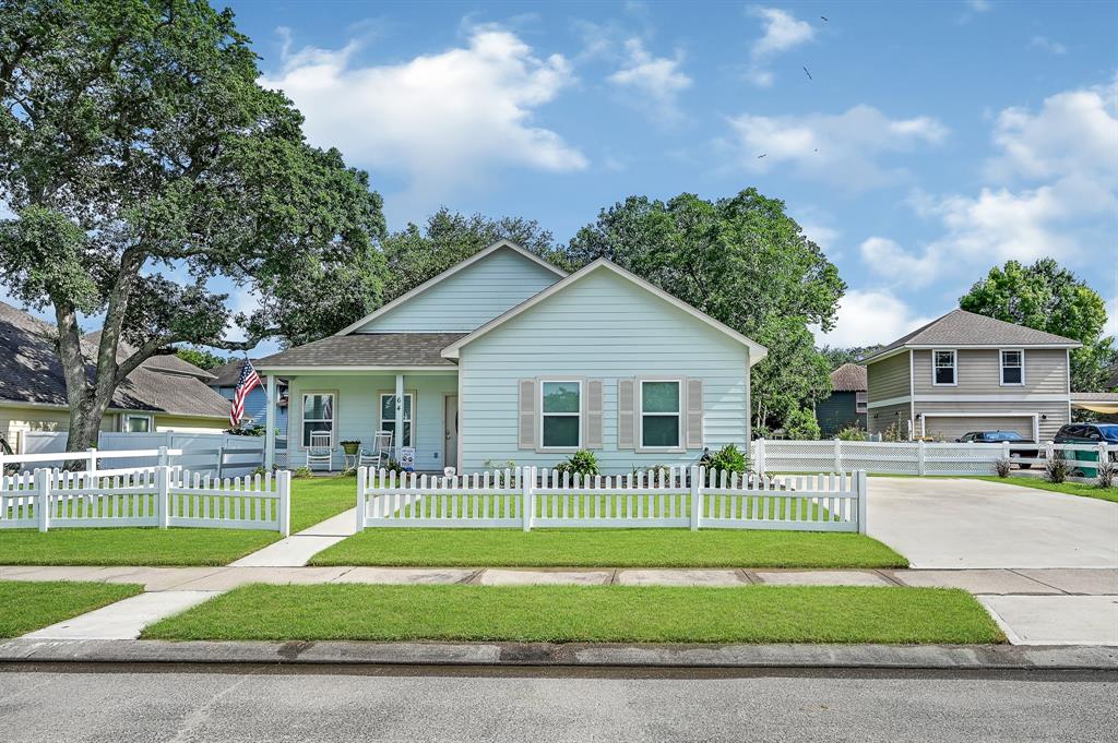 a view of a house with a yard and fence