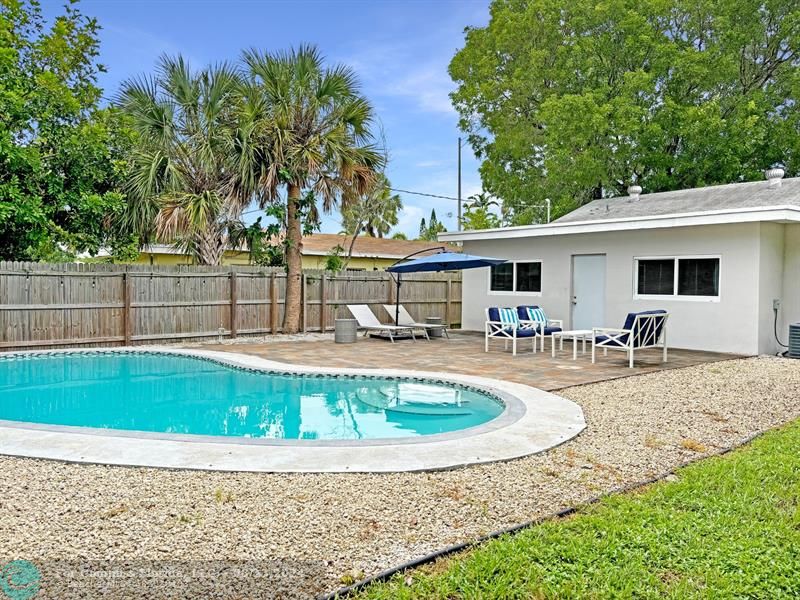 a view of a house with swimming pool and sitting area