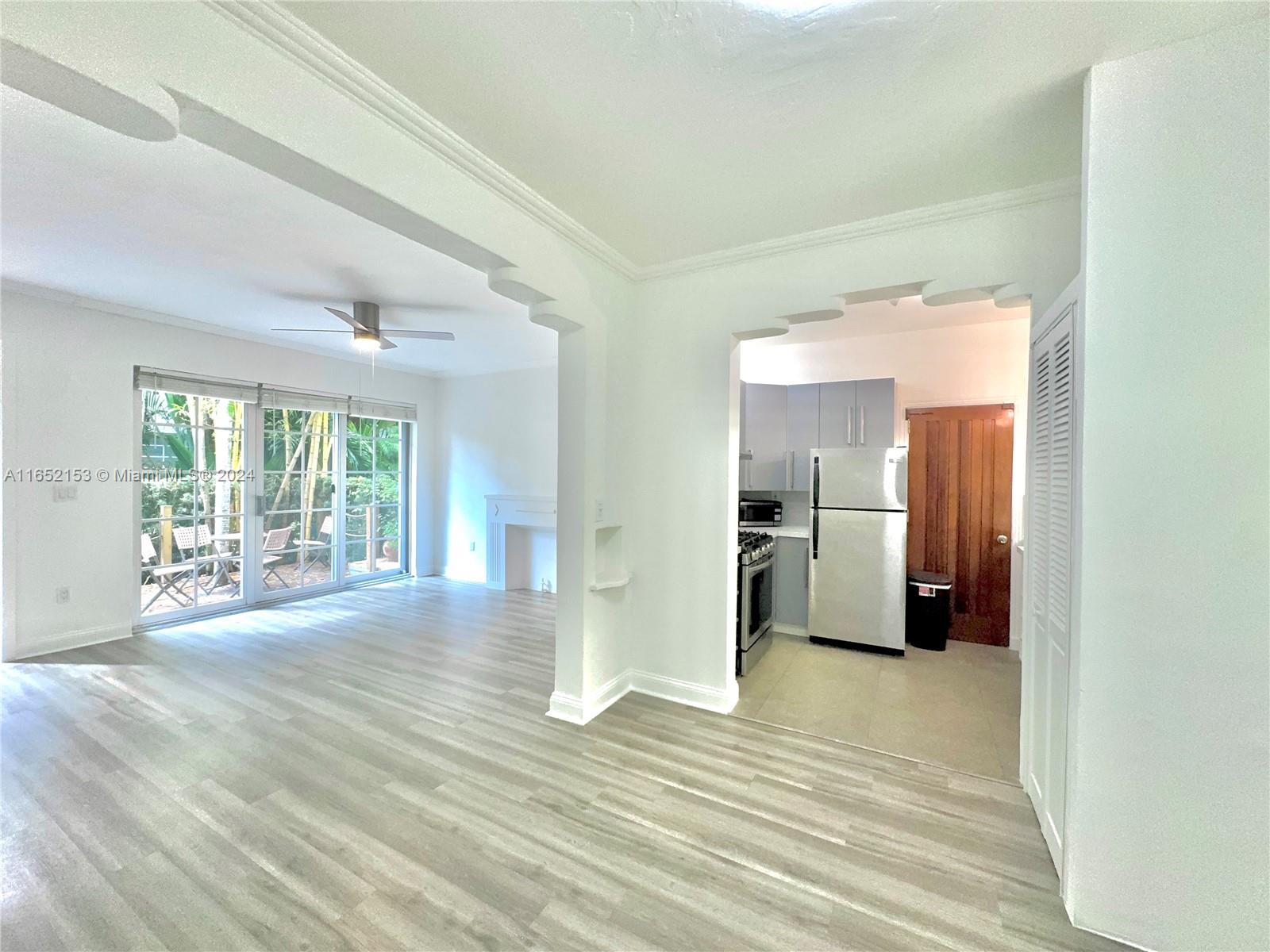 a view of a big room with wooden floor and windows