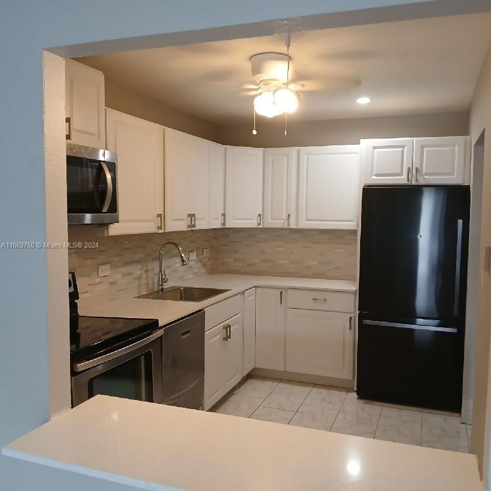 a kitchen with a sink appliances and cabinets