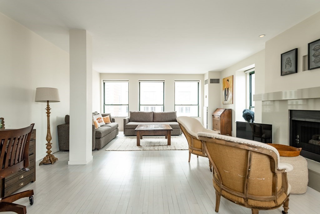 a living room with furniture fireplace and a large window