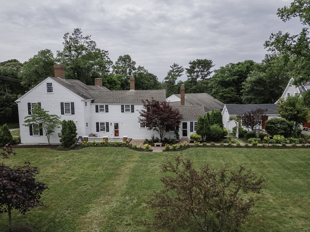 a front view of a house with a garden and trees