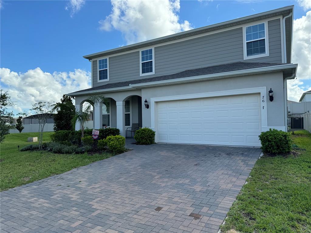 a front view of a house with a yard and garage