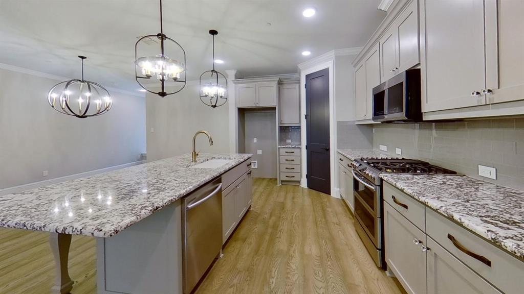 a kitchen with granite countertop stainless steel appliances lots of counter space and wooden floor