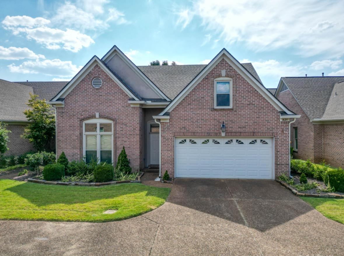 View of front of house featuring a garage and a front yard