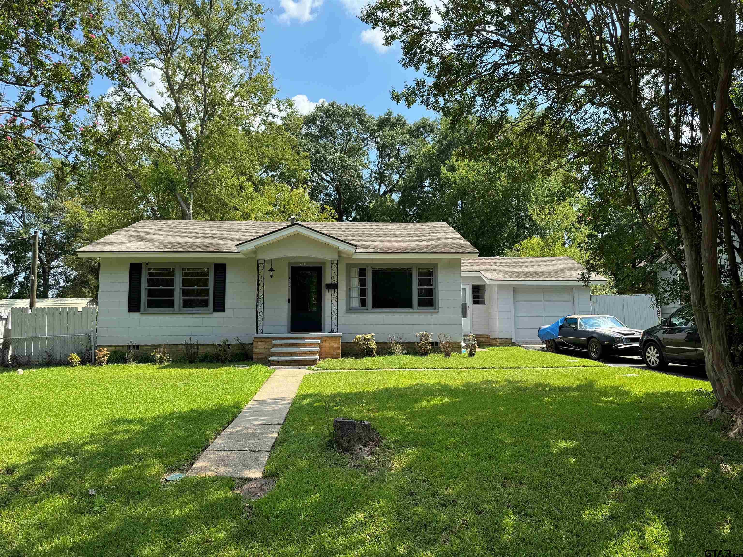 a front view of a house with a yard and trees