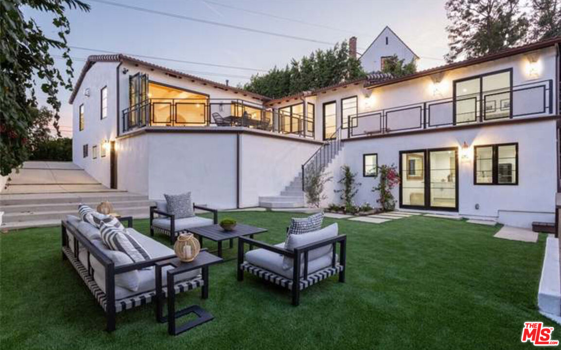 a view of a house with backyard and sitting area