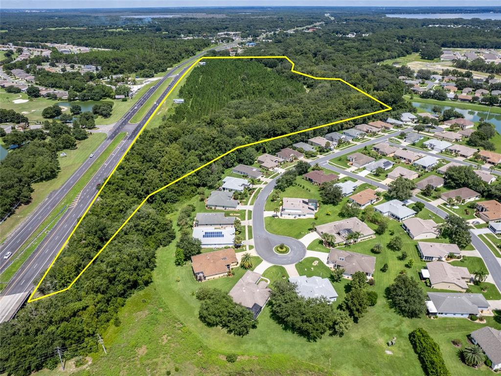 an aerial view of a residential houses with outdoor space and trees