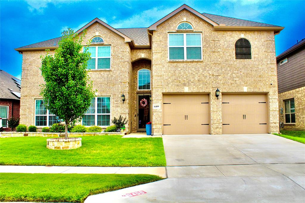 a front view of a house with a yard and garage