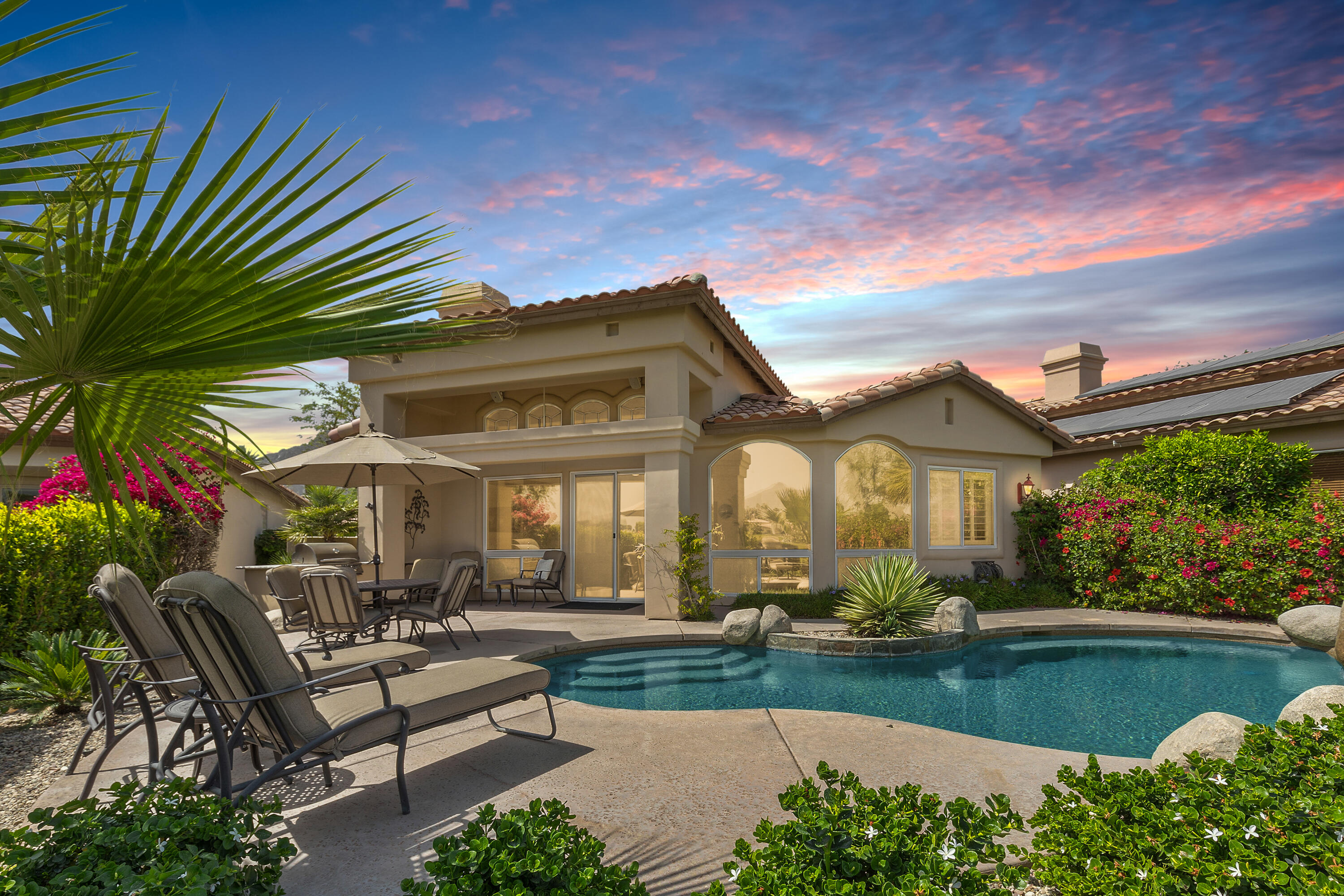 a view of house and outdoor space with swimming pool and furniture