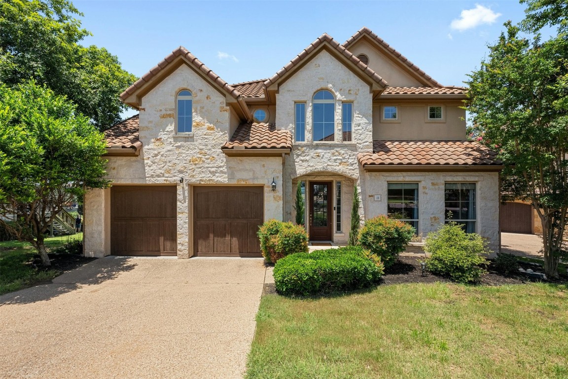 a front view of a house with a garden and plants