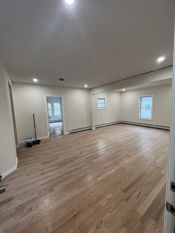 an empty room with window and wooden floor