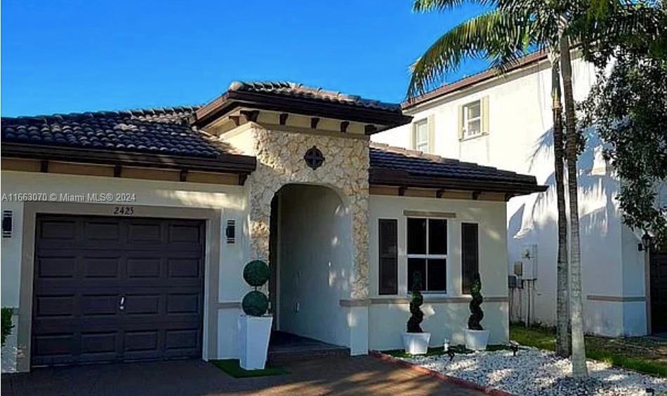 a front view of a house with a tree