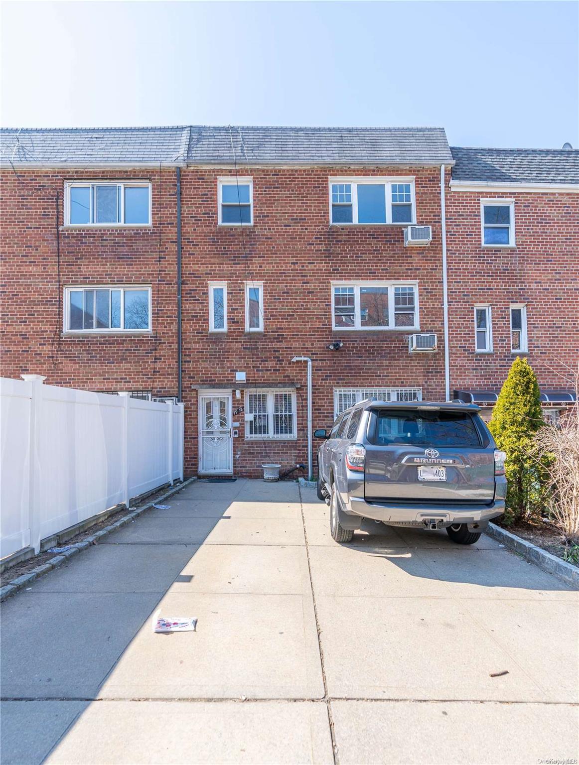 a car parked in front of a brick house