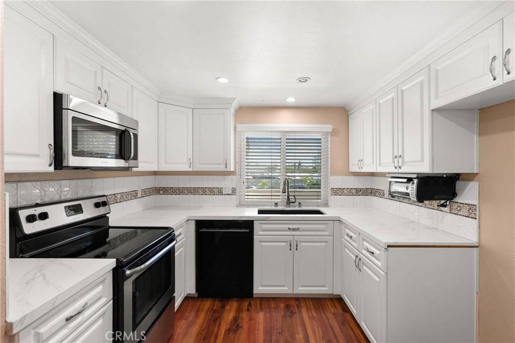 a kitchen with a sink stove top oven and microwave